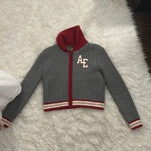 I’m selling a grey and red American Eagle zip up with a AE patch on the front.
